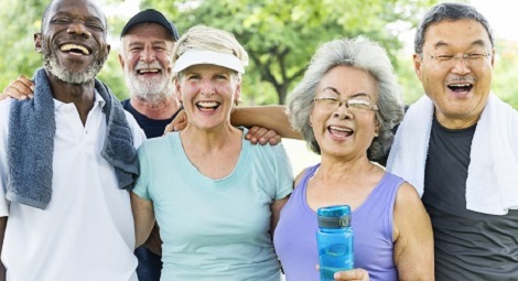 Group of older people smiling after exercise with water bottles and towels